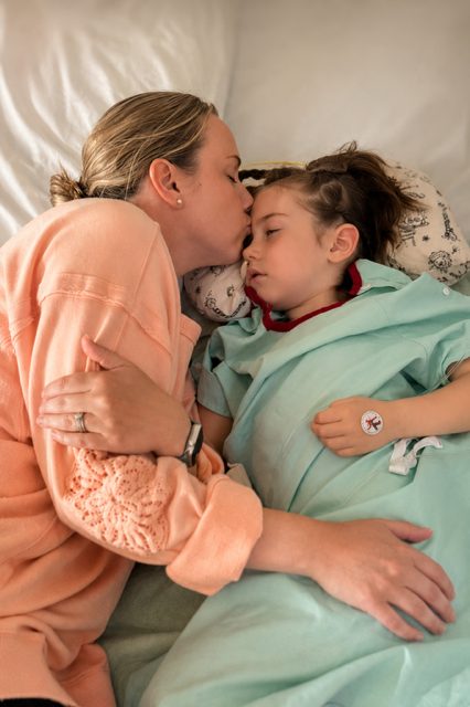 Amanda gently kissing Evelyn’s forehead in the hospital